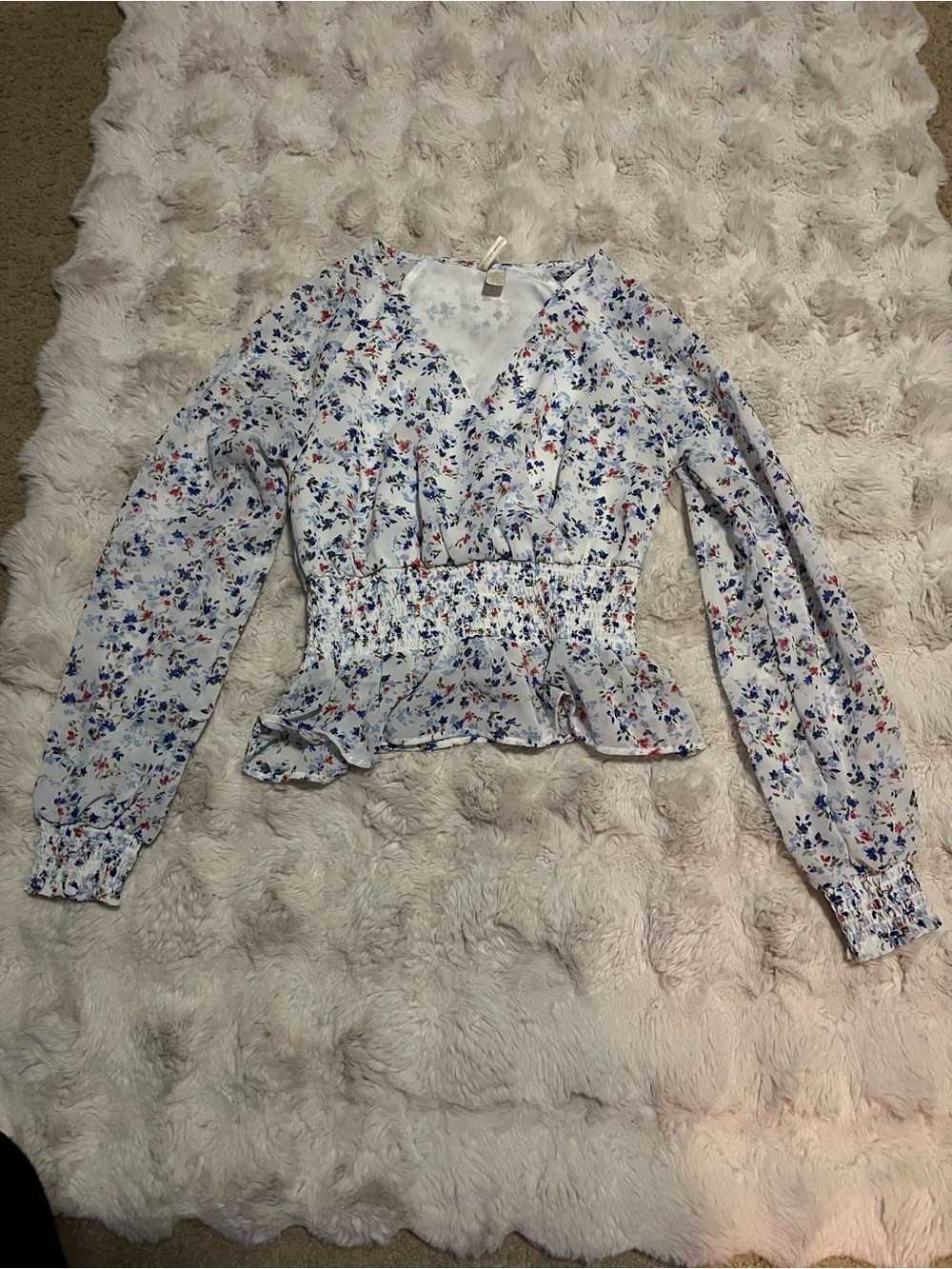 white and blue floral blouse with a synched waist and ruffle sleeves, size S.